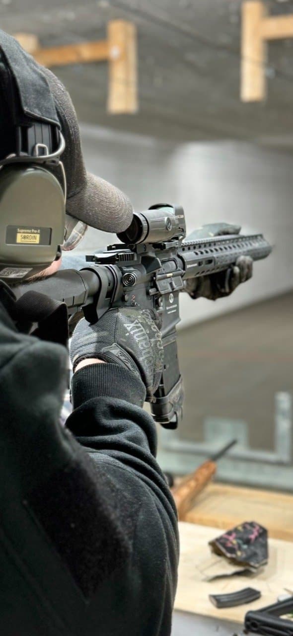 Sportschütze mit Schutzbrille, Gehörschutz und Langwaffe im Training